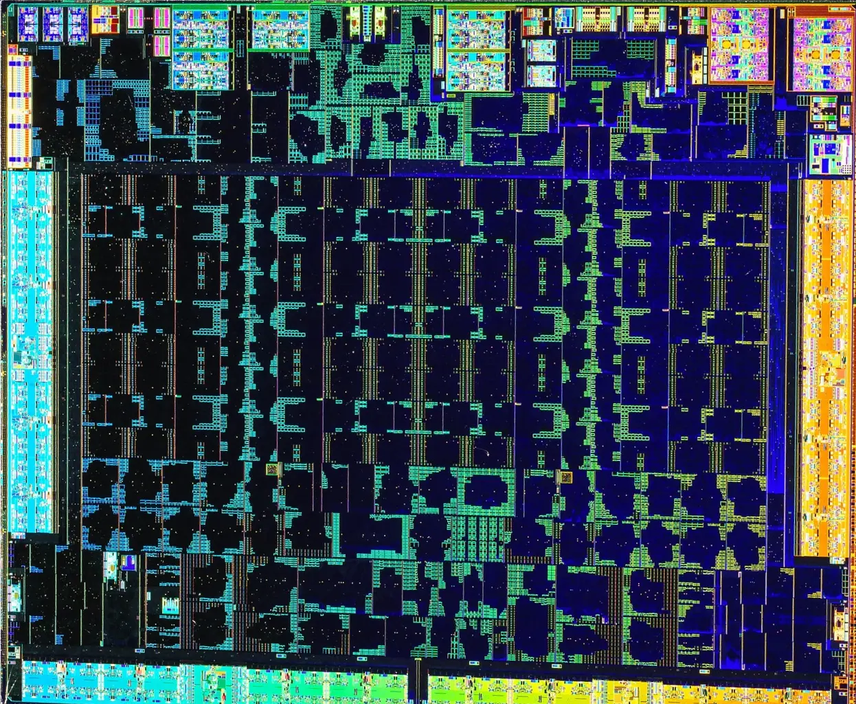 An AMD Navi 14 GPU die photographed under a microscope, its compute units picked out in cyan, orange and deep blue